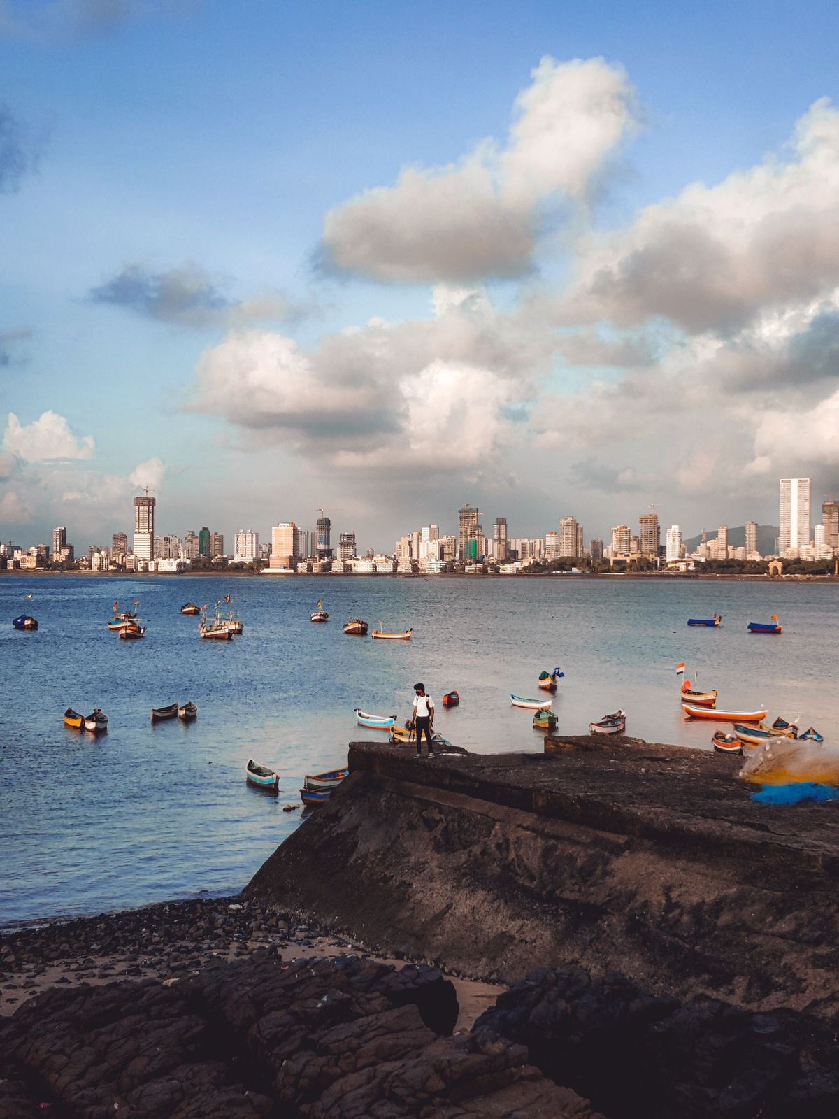 Boats in a bay below the Mumbai skyline