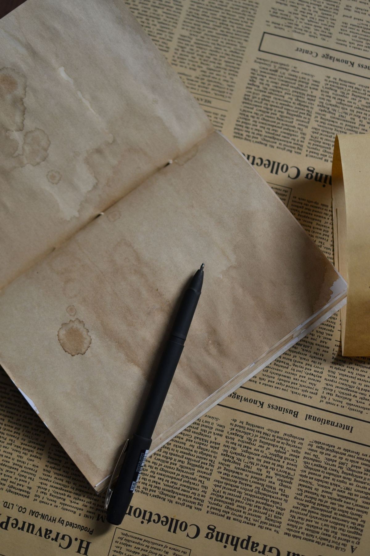Notebook and pen on newspaper, overhead